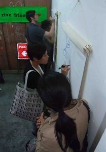 Passersby draw on the zine wall...